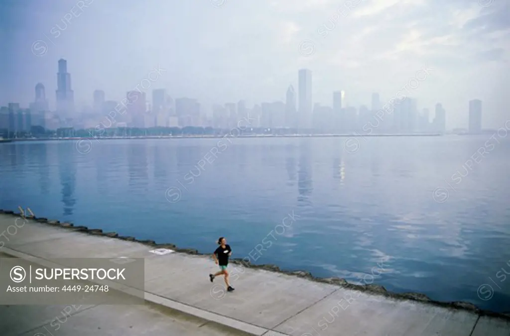 Young man jogging on shore of Lake Michigan, Northerly Island Park, Chicago, Illinois, USA