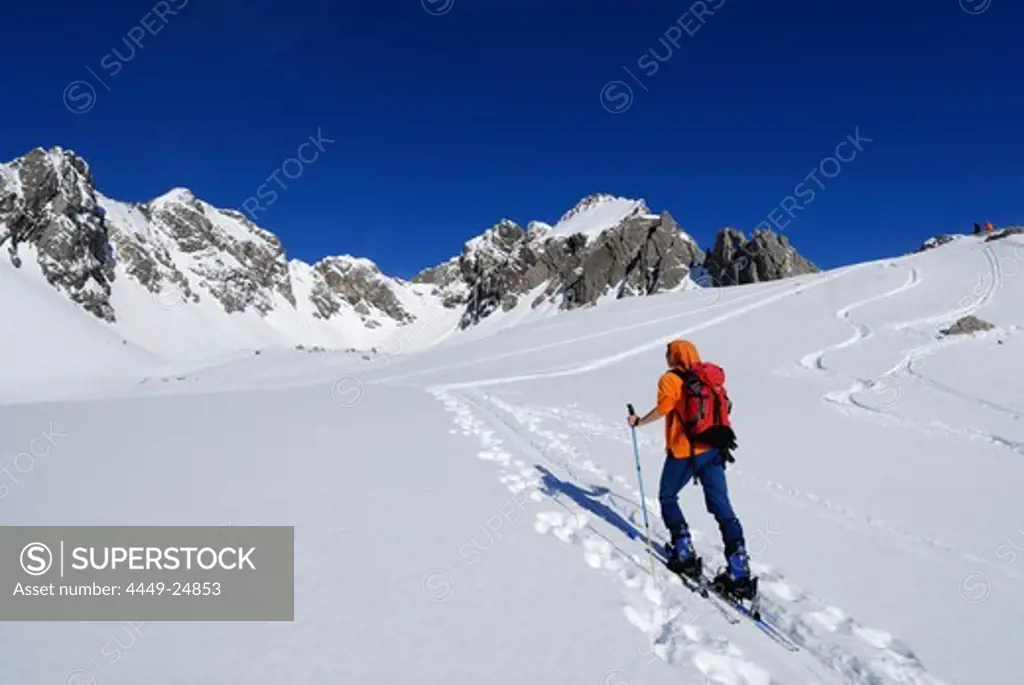 young woman ascending Haglertal with view to Satteltal, Allgaeu range, Allgaeu, Tyrol, Austria