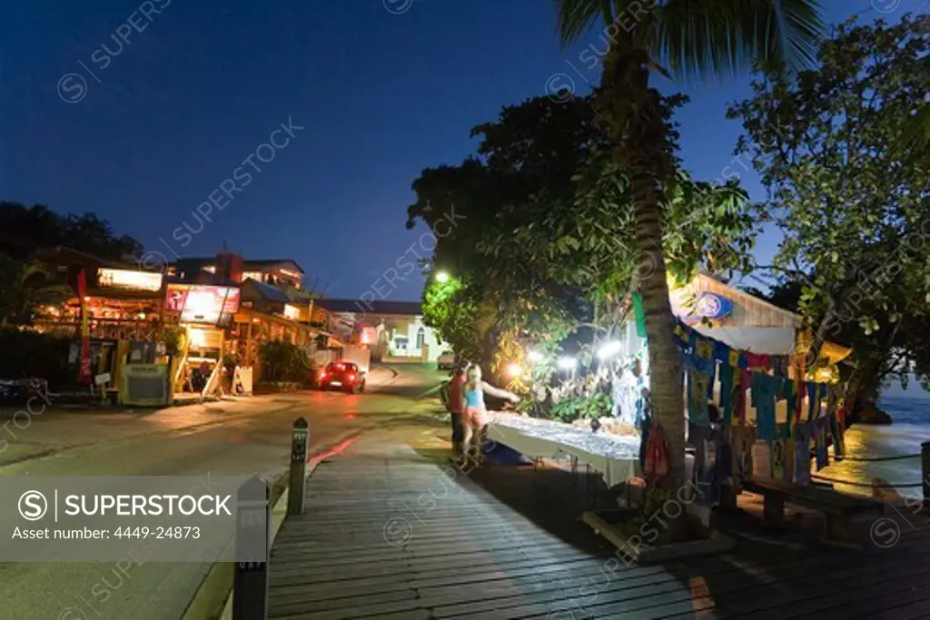Tourists at souvenir stand at night, St. Lawrence Gap, Barbados, Caribbean