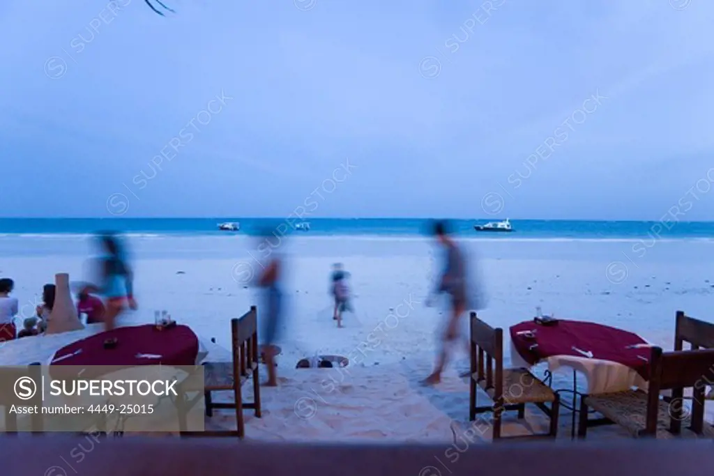People passing a beach restaurant, The Sands, at Nomad, Diani Beach, Kenya