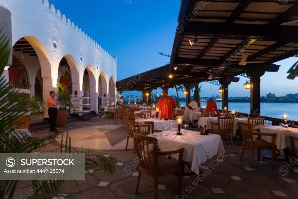 Waiters decorating tables on terrace of the restaurant Tamarind, Mombasa, Kenya