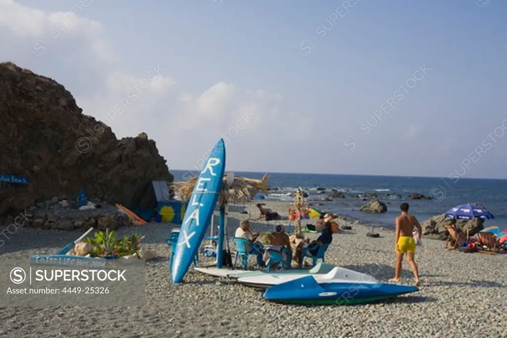 People relaxing on the beach Relax sign, Akro Pornos, near Polis, South Cyprus, Cyprus