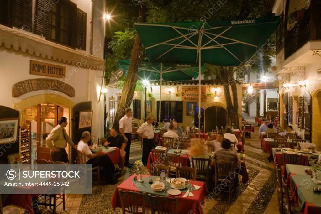 Life in the city, people sitting outside Rimi Restaurant at night enjoying an evening meal, Laiki Geitonia, Lefkosia, Nicosia, Cyprus
