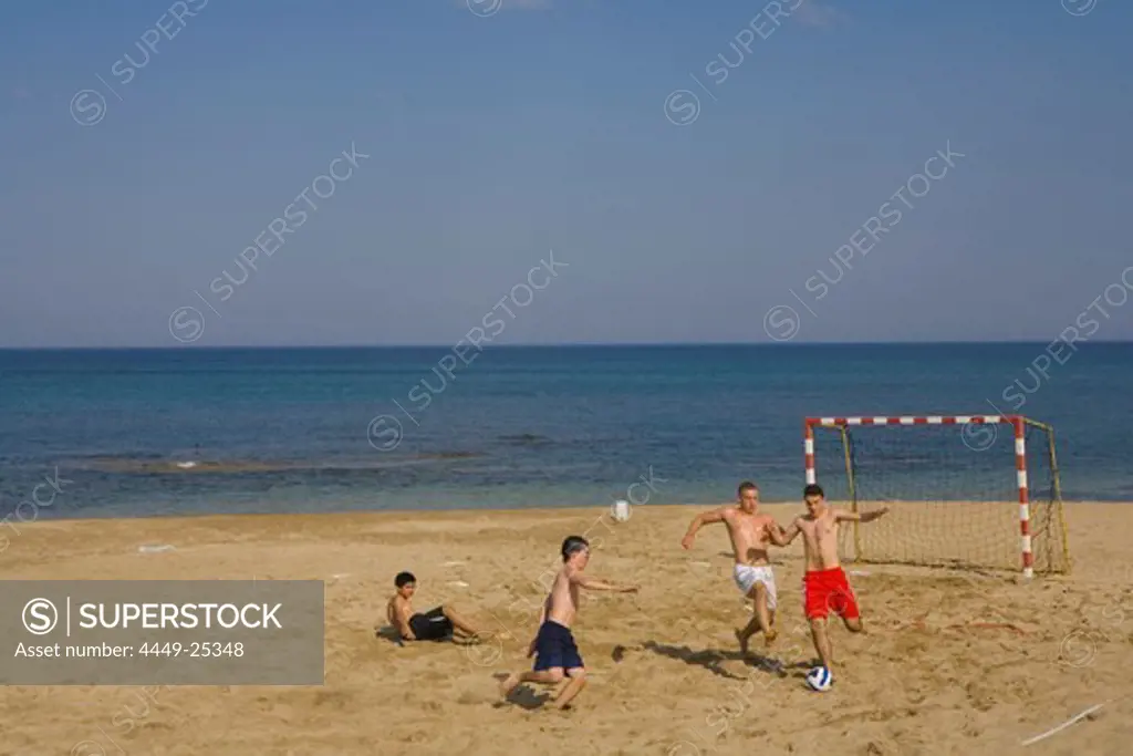 Boys and young men playing football on Salamis beach, Salamis, Cyprus