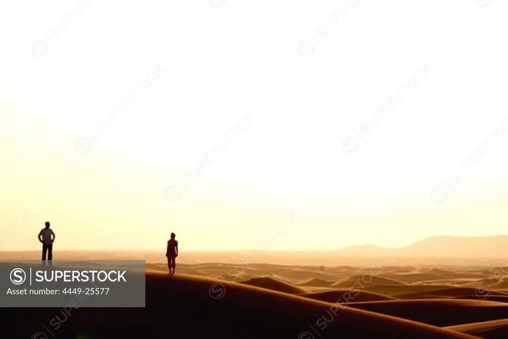 Silhouette of Couple in the Desert watching sun set, Dubai, United Arab Emirates, UAE