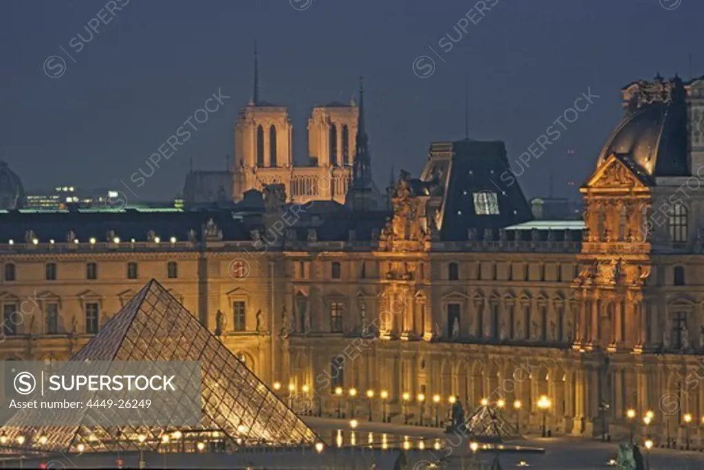 Louvre Museum with IM Pei Pyramide and Notre Dame in background, illumated at night, Paris, France