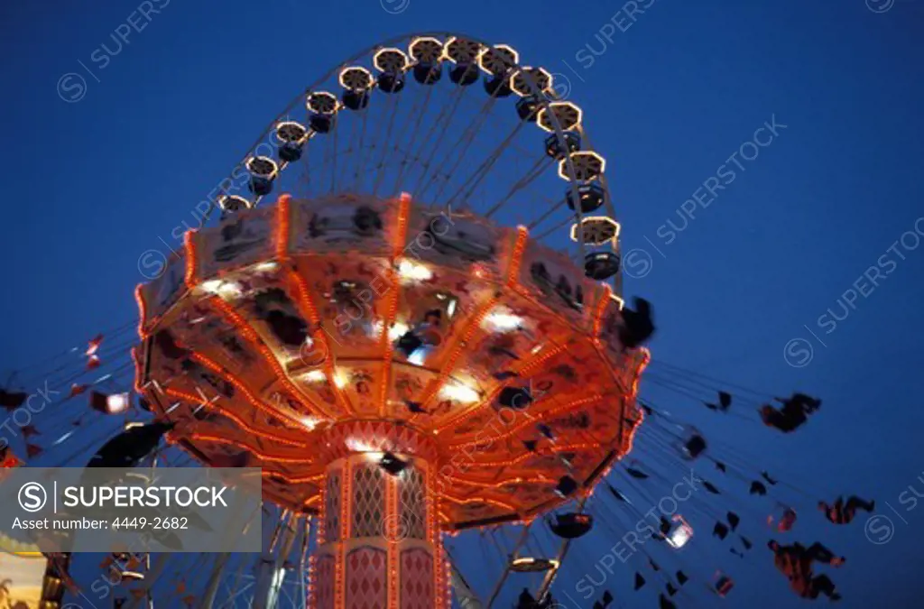 Illuminated fairground ride in the evening, Bad Cannstatt fair, Stuttgart, Baden Wuerttemberg, Germany, Europe