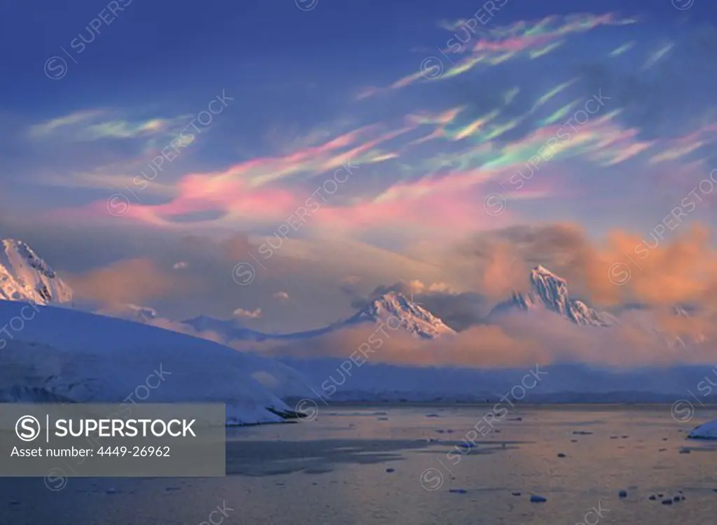 Mother of pearl clouds, nacreous clouds over snow covered iceberg, Antarctic Peninsula, Antarctica