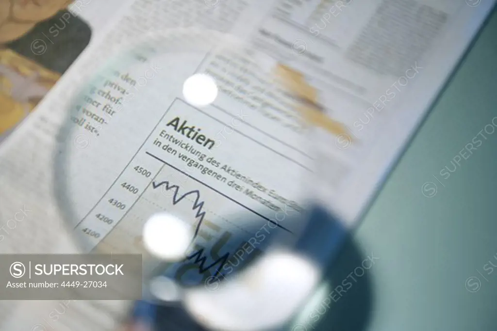Person looking at shares, stock report through a magnifying glass, Newspaper, Business, Economy, Finance, Stock Exchange