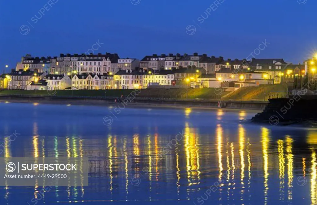View at illuminated houses on shore in the evening, Portrush, County Antrim, Ireland, Europe