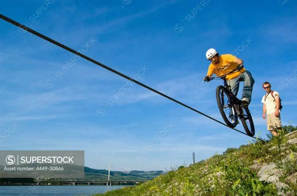 Trial biker on steel rope at Danube River, Linz