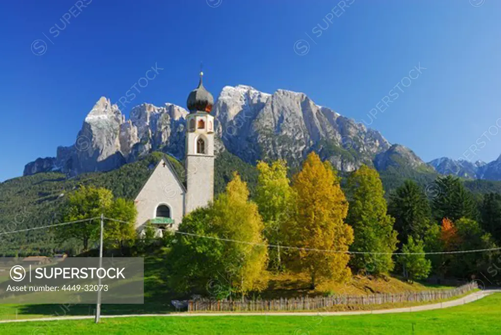 church St. Konstantin with trees in autumn colours beneath Schlern, Dolomites, South Tyrol, Italy