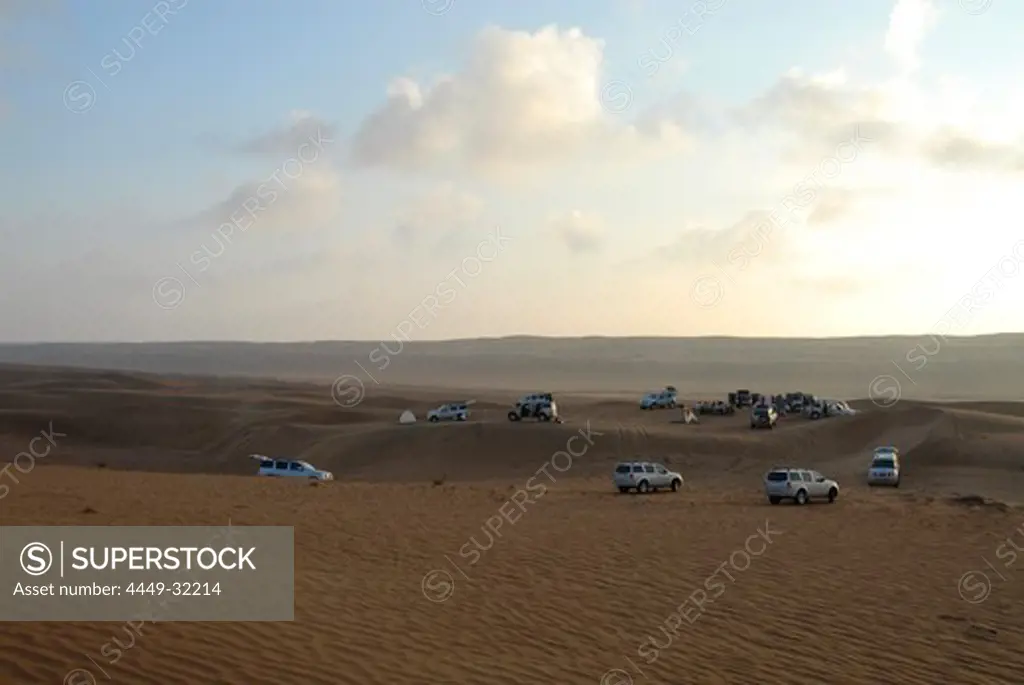 All-terrain vehicles standing in the sands of the desert at dawn, Wahiba Sands, Oman, Asia