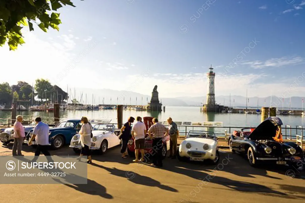 Harbour and harbour entrance to Lindau, Lake Constance, Lighthouse, 33 meters high, and Bavarian Lion sculpture in the background, Oldtimer Rallye on the promenade, Lindau Classics, Lindau, Bavaria, Germany