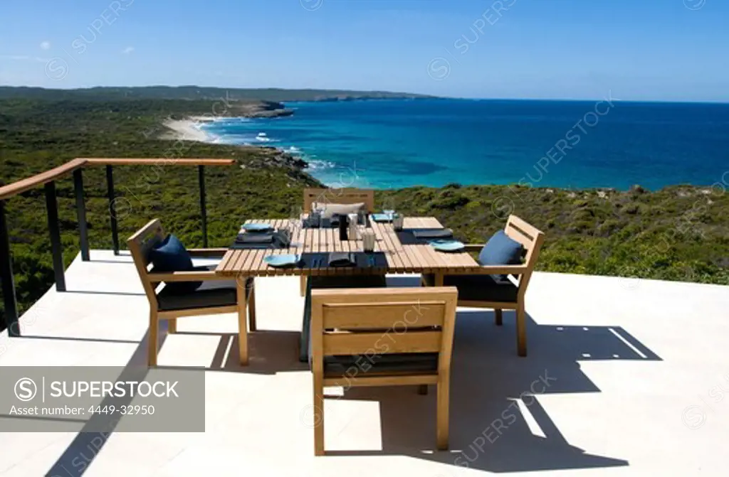 A table is laid at the terrace of the Southern Ocean Lodge in the sunlight, view at Hanson Bay, Kangaroo Island, South Australia, Australia