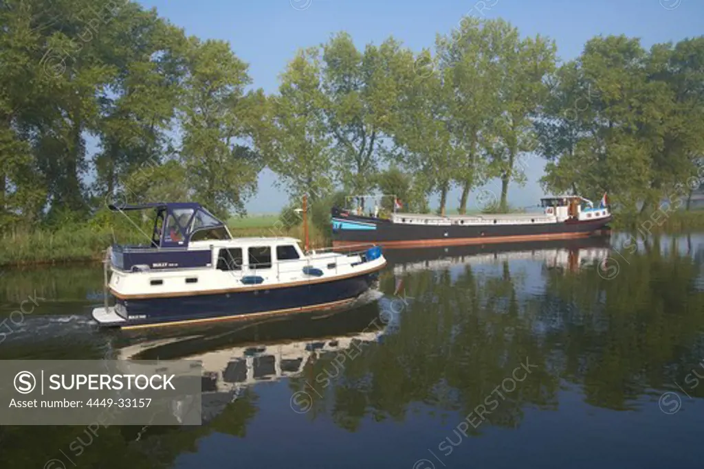 A freighter and a houseboat on the river Vecht, Netherlands, Europe
