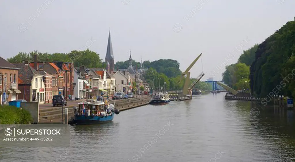 Boats are moored at the banks of Merwede canal, bascule bridge in the background, Nieuwwegein, Netherlands, Europe