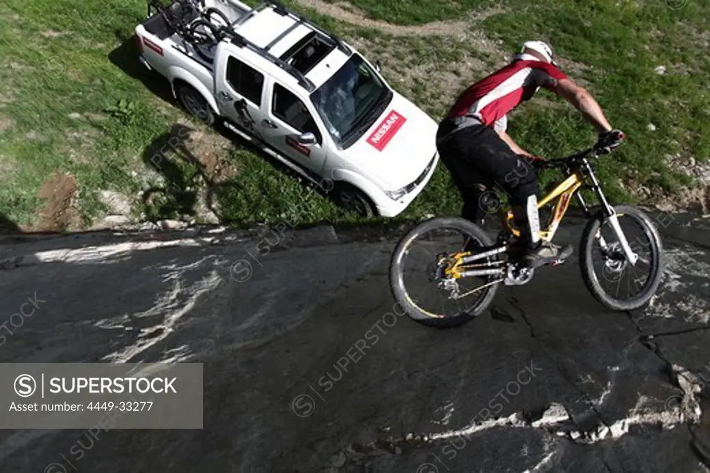Mountainbiker riding on a steep rock face, Ischgl, Tyrol, Austria