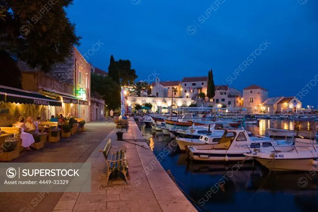 People sitting in front of a tavern at Bol harbour in the evening, Brac Island, Dalmatia, Croatia, Europe