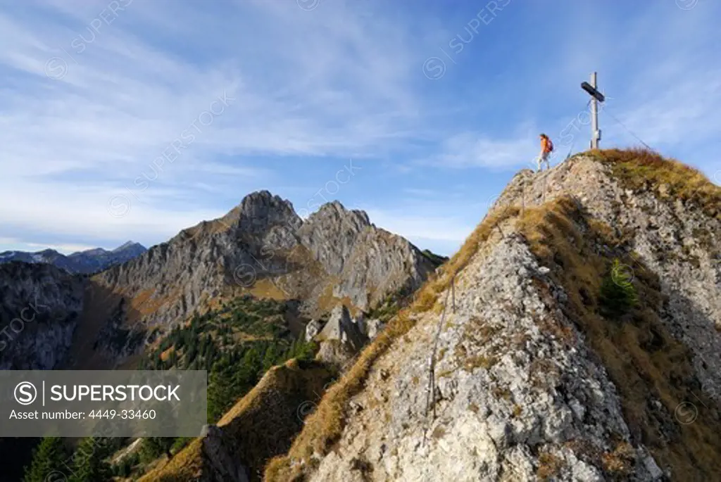 Woman enjoying view at summit cross of mount Brunnenkopf, Ammergau Alps, Pfaffenwinkel, Bavaria, Germany