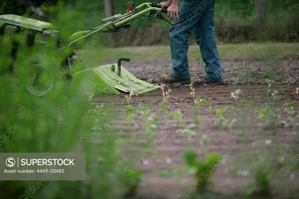 Farmer using rotary tiller, biological dynamic (bio-dynamic) farming, Demeter, Lower Saxony, Germany