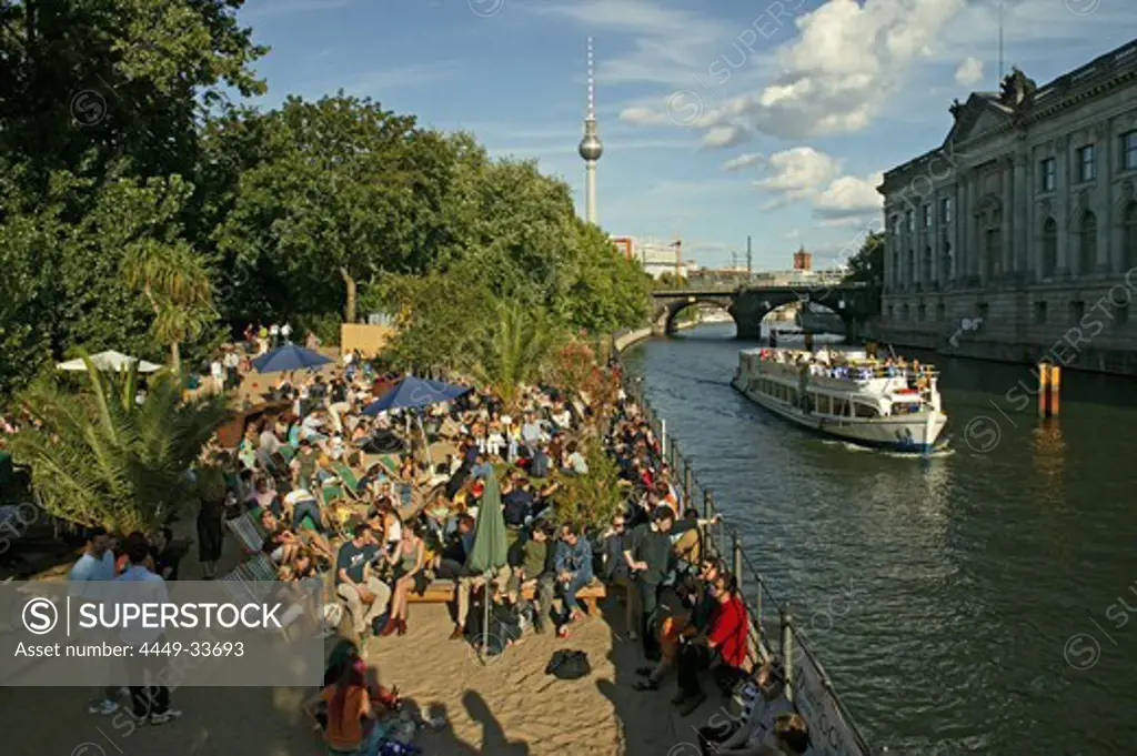 People relaxing at the bank of the river Spree in the sunlight, Museum Island, Berlin, Germany, Europe