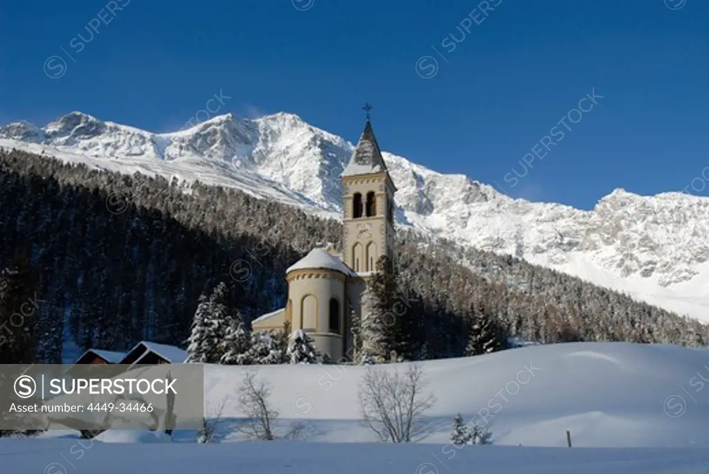 The church St. Gertraud in front of snow covered mountains under blue sky, Sulden, Val Venosta, South Tyrol, Italy, Europe