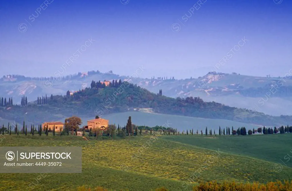 Hilly landscape with country houses under blue sky, Tuscany, Italy, Europe