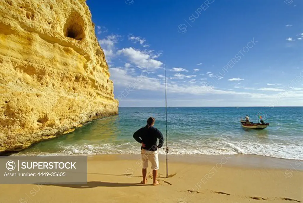 Angler on the beach under blue sky, Praia da Marinha, Algarve, Portugal, Europe