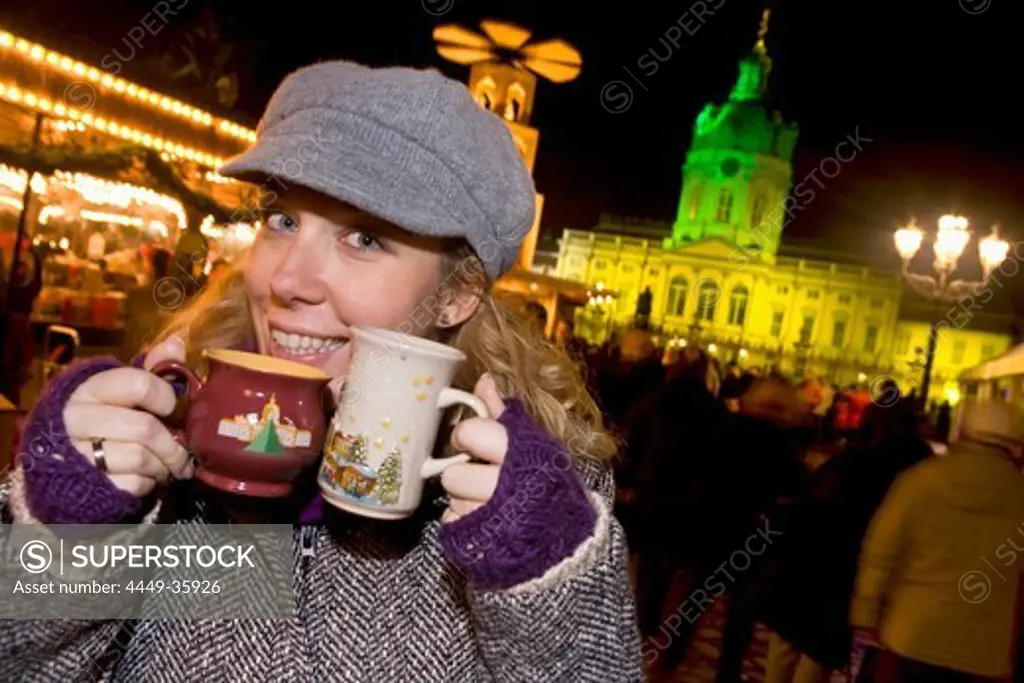 Girl enjoying mulled wine at the Christmas market at Schloss Charlottenburg, Berlin, Germany