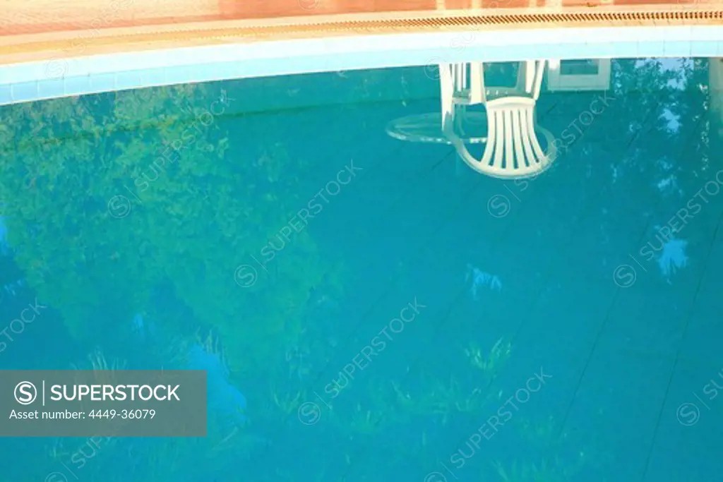 A chair reflecting in the pool of the Golden Express Hotel, Bagan, Myanmar, Burma, Asia
