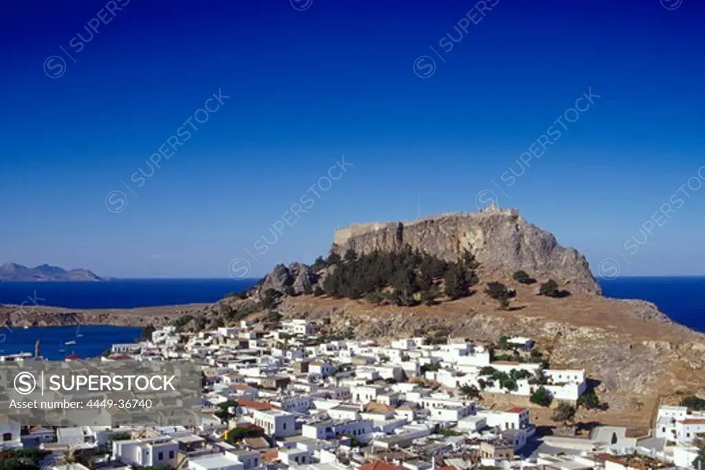 The town LIndos and the acropolis under blue sky, Lindos, Island of Rhodes, Greece, Europe