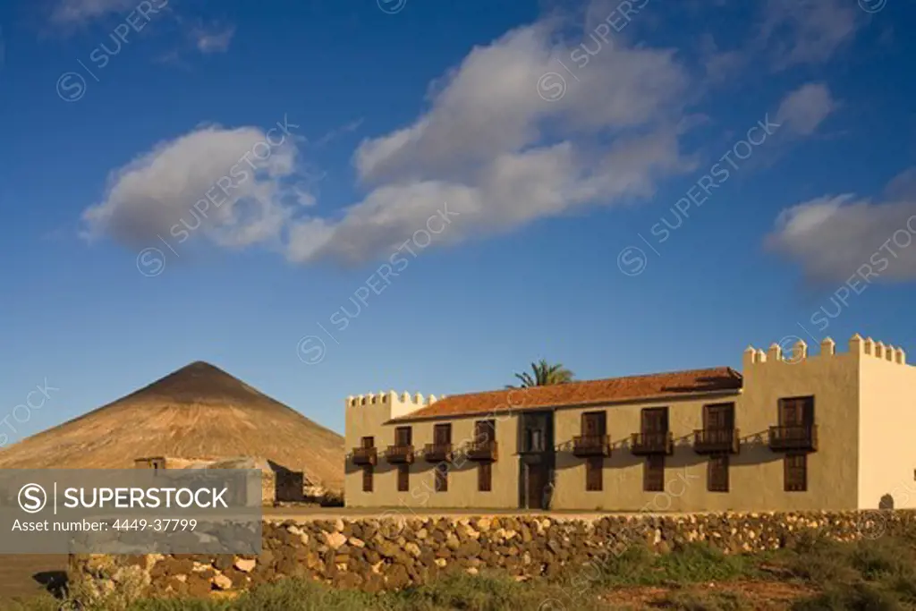 The extinct volcano Montana Oliva behind the historical building Casa de Los Coroneles, La Oliva, Fuerteventura, Canary Islands, Spain, Europe
