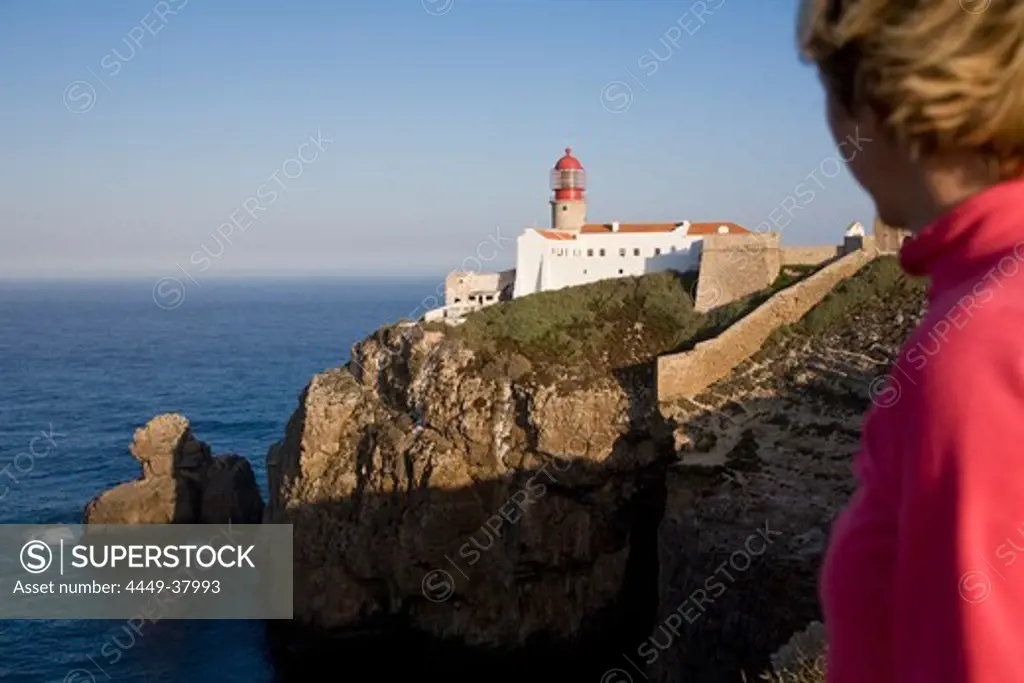 Young woman at the lighthouse at Cape Cabo de Sao Vicente, Atlantic Ocean, MR, Sagres, Algarve, Portugal