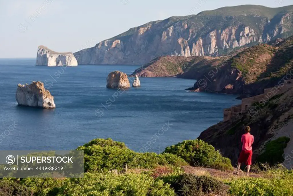 Pan di Zucchero, woman looking at rock off shore, Masua, Sardinia, Italy, Europe