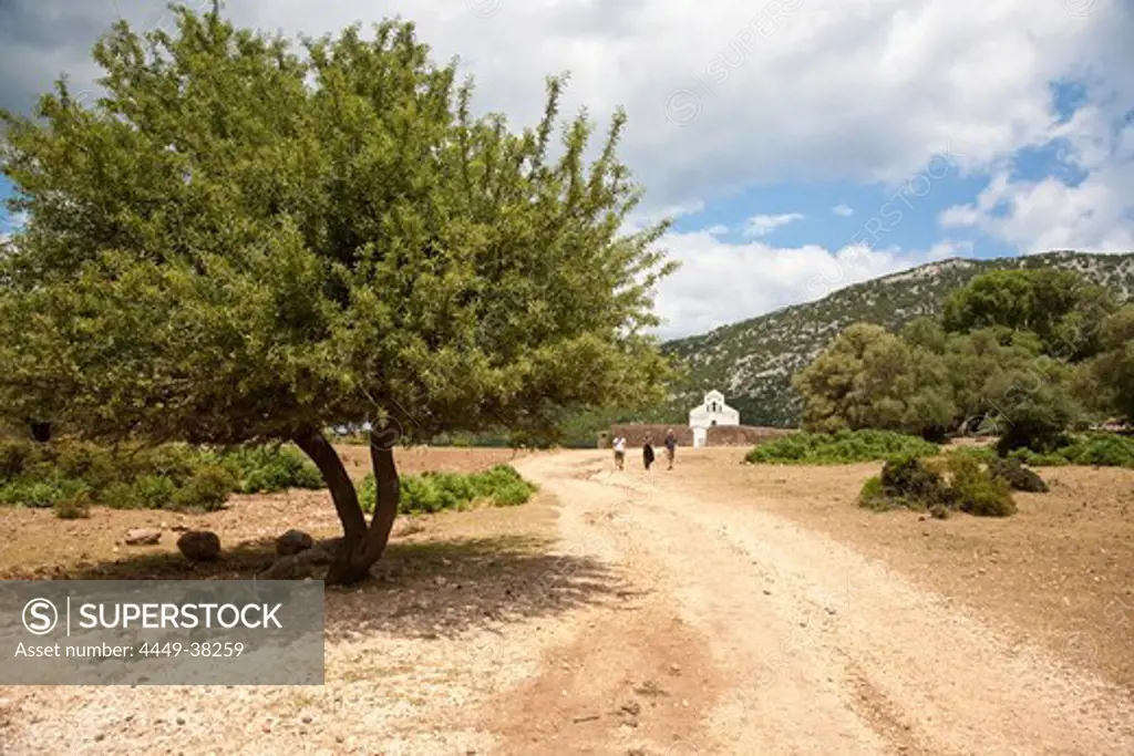 Country road and little church under clouded sky, Altiplano Su Golgo, Sardinia, Italy, Europe