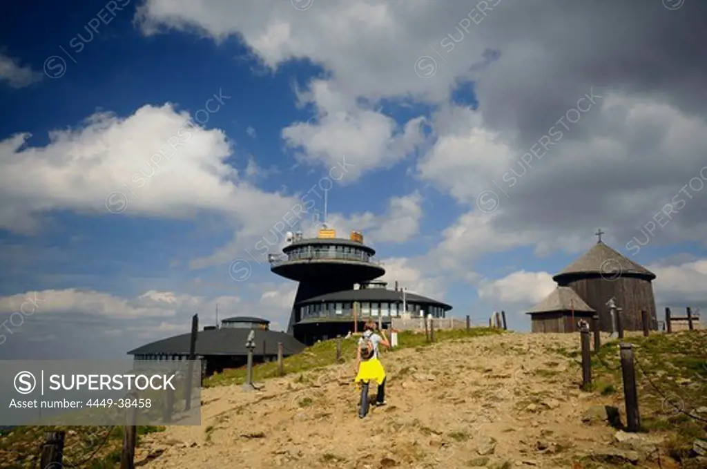 Hiker in front of buildings on the summit of the Schneekoppe, Bohemian mountains, Lower Silesia, Poland, Europe