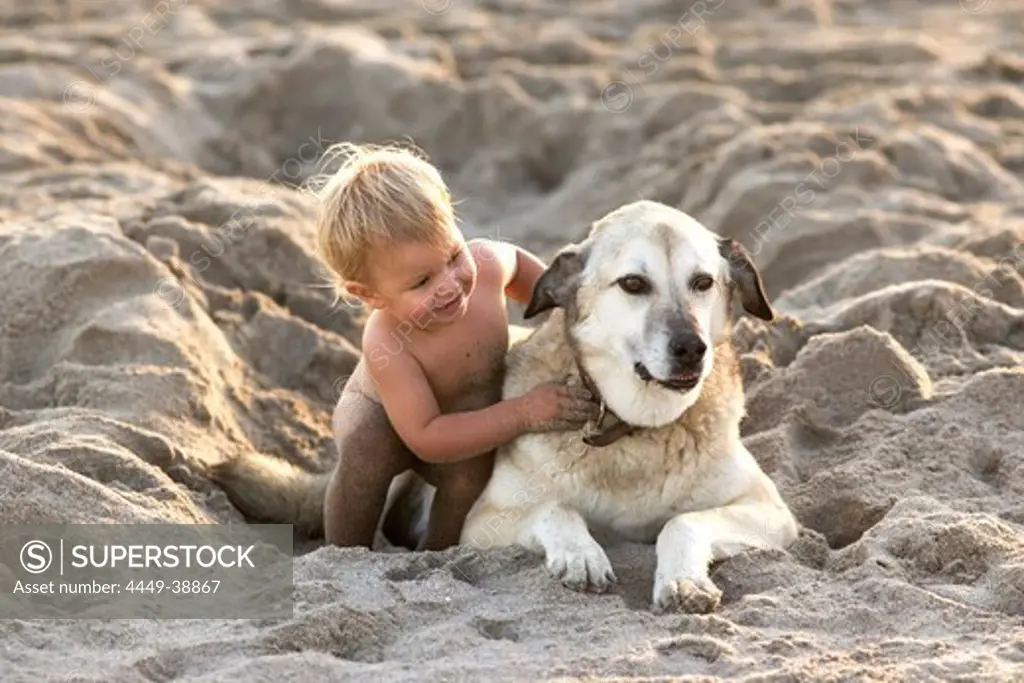 Little girl playing in the sand with a dog, Punta Conejo, Baja California Sur, Mexico, America