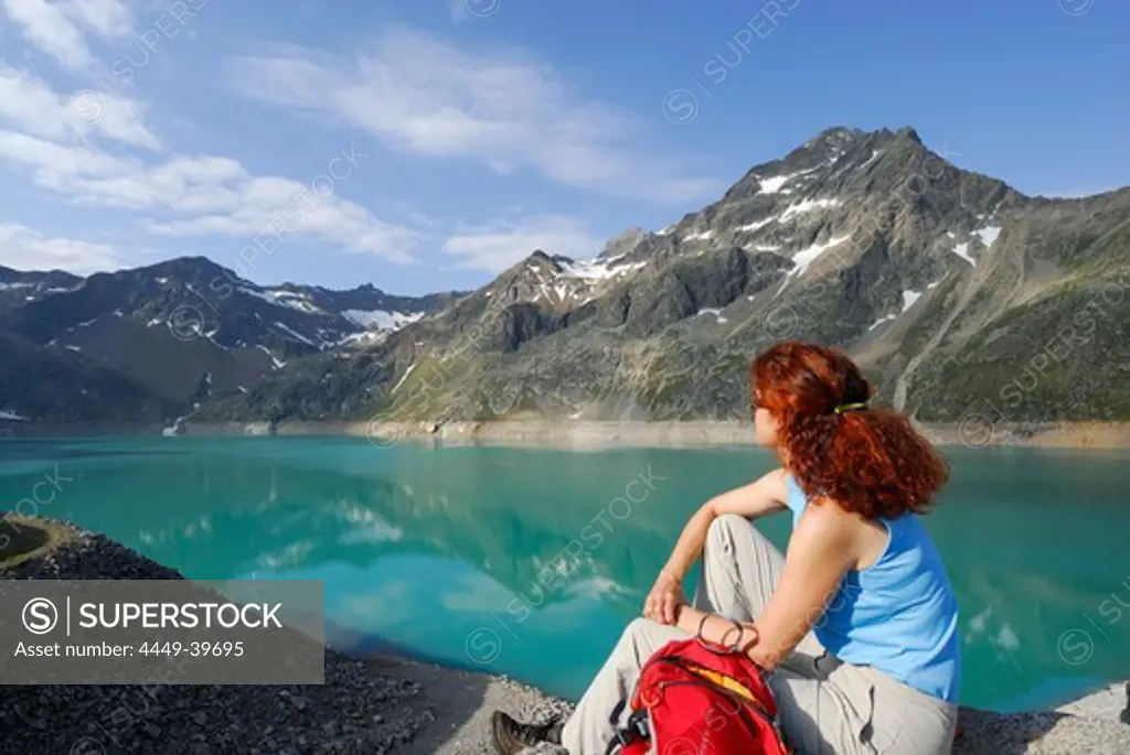 Woman looking over reservoir Finstertal, Sellrain, Stubai Alps, Tyrol, Austria