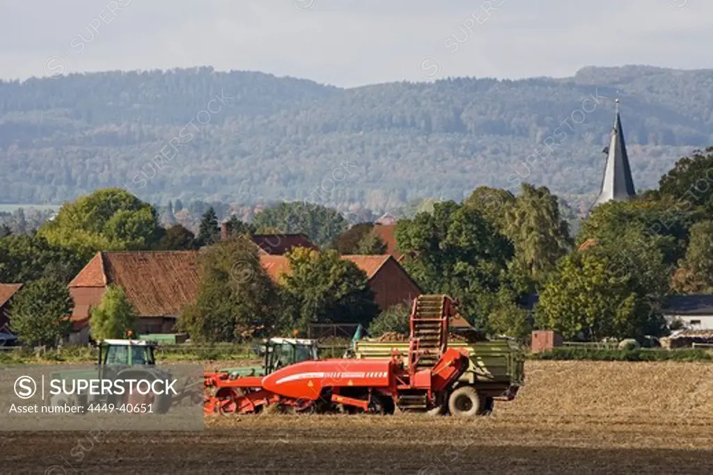 tractor working in the field, village, agriculture, rural landscape, northern Germany