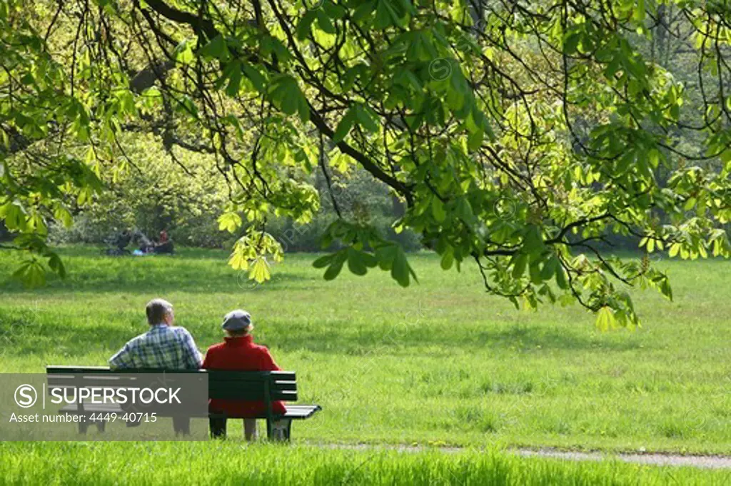 couple sitting on a bench in Georgengarten, Herrenhausen, Hannover, Germany