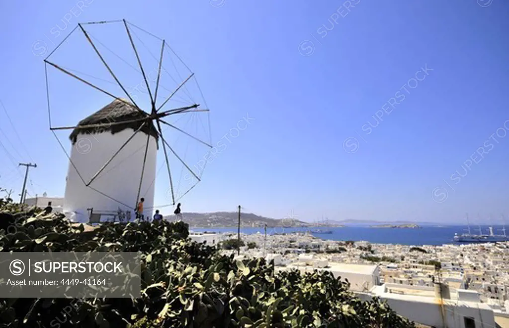 Windmill and view of the town in the sunlight, island of Mykonos, the Cyclades, Greece, Europe