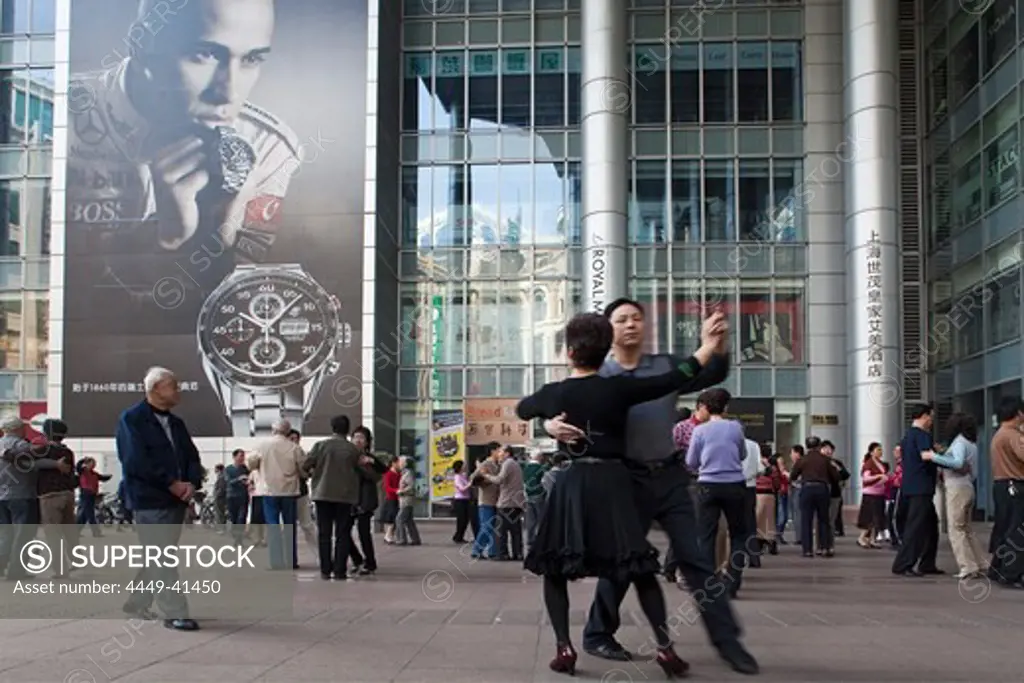 People dancing under the arcades of a building, Nanjing Road, Shanghai, China, Asia