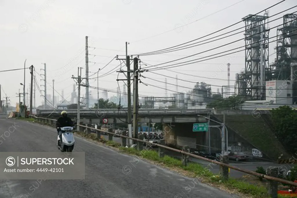 Man on scooter on a road next to chemical plant, west coast, Gaoxiong, Kaohsiung, Republic of China, Taiwan, Asia