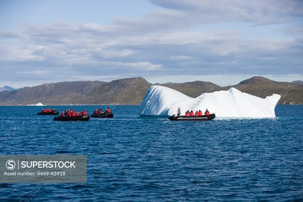 People in rubber dinghies driving to iceberg, Kitaa, Greenland