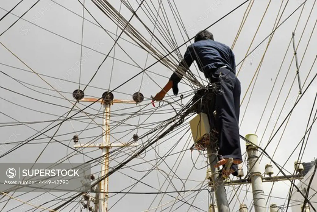 Electrician in a ravel of wires in dowtown Hyderabad, Andhra Pradesh, India, Asia
