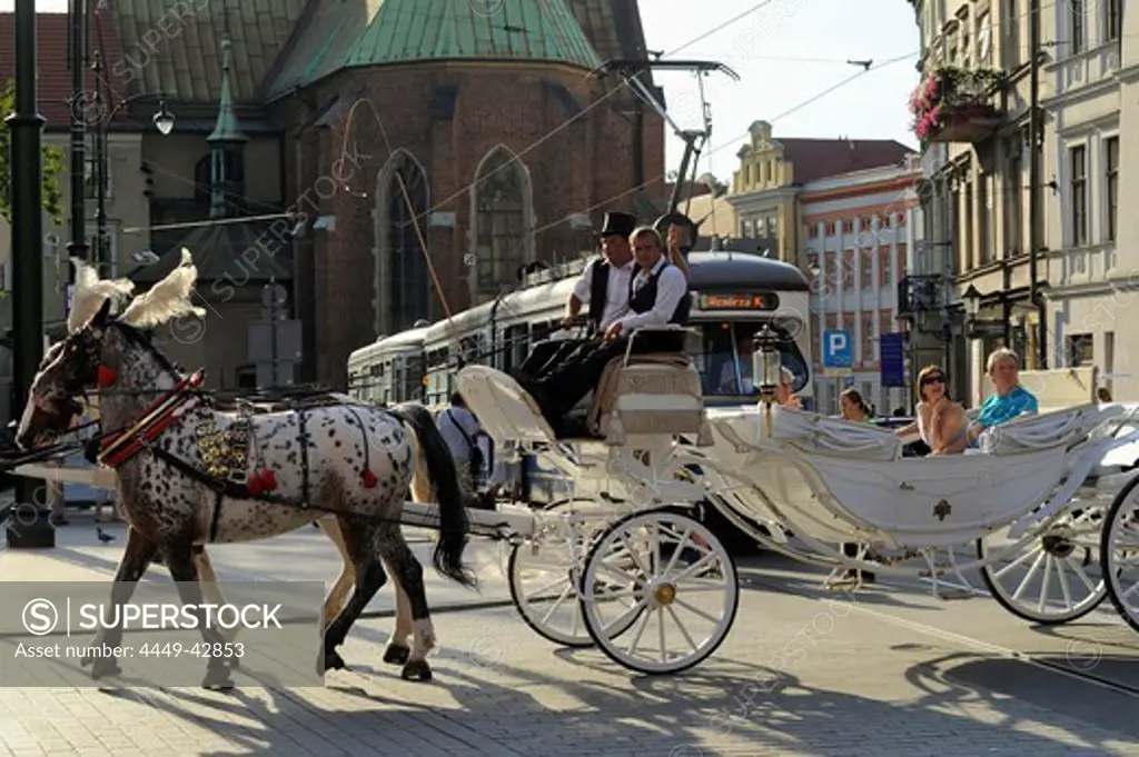 Horse-drawn carriage with tourists in front of tram at ul. Gradzka Ecke Dominikanska, Krakow, Poland, Europe