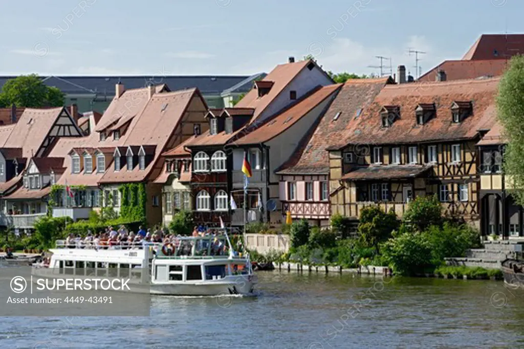 Tourist boat on river Regnitz in the houses of little Venice, Bamberg, Upper Franconia, Bavaria, Germany