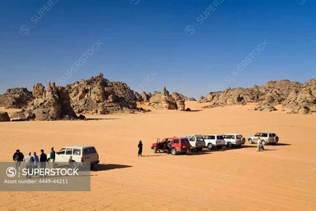 Jeeps and tourists in stony desert, Akakus mountains, Libya, Sahara, North Africa