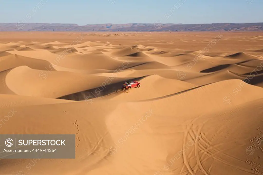 Jeep driving across the sand dunes, Dunes de Juifs, desert near Zagora, Sahara, Morocco